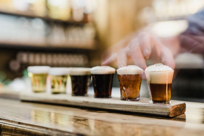 Cropped hands holding beer glass on table