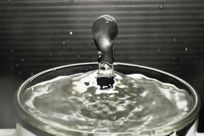 Close-up of drop falling on glass