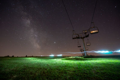 Chair lift on field against sky at night