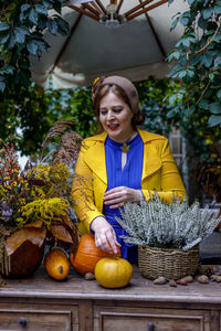 Portrait of young woman standing amidst plants