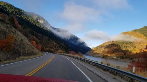 Road by mountains against sky