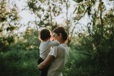 Rear view of mother holding daughter 