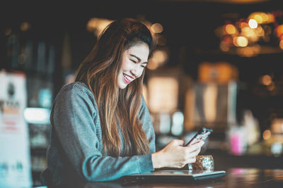 Young woman using mobile phone at night