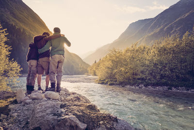 Slovenia, bovec, three friends at soca river at sunset