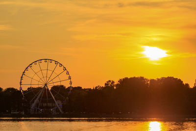 Silhouette ferris wheel against sky during sunset