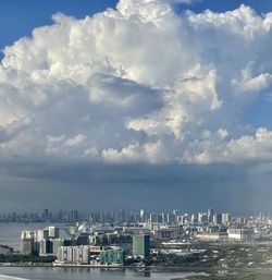 City buildings by sea against sky