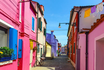 Street amidst houses against sky