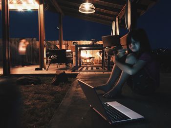 Woman using mobile phone while sitting on table