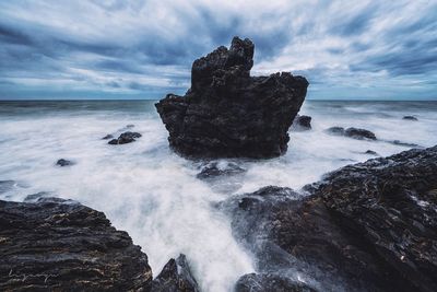 Rock formation in sea against sky