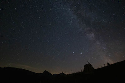 Low angle view of silhouette landscape against sky at night