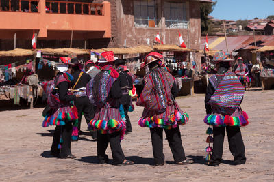 Rear view of people walking on street in city