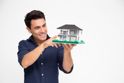Portrait of smiling young man against white background