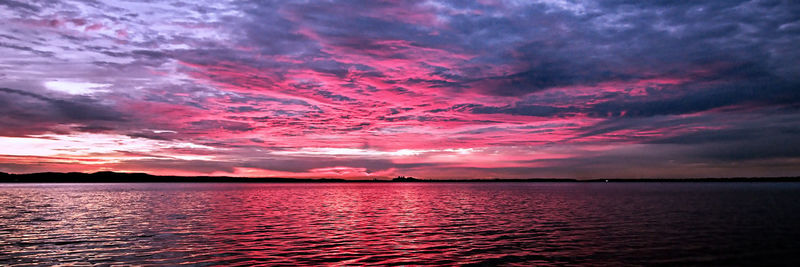 Scenic view of sea against dramatic sky during sunset