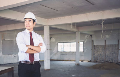 Confident engineer standing at construction site