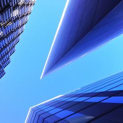 Low angle view of tall building against clear blue sky