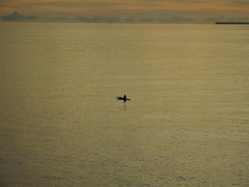 Boat sailing in sea against sky during sunset