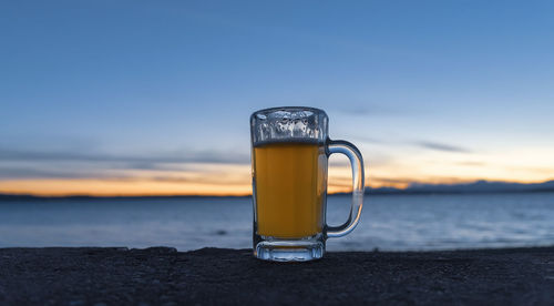 Beer in a mug at sunset, wide view.