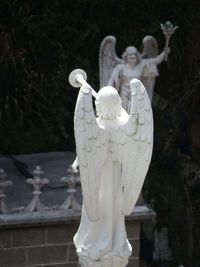 Close-up of angel statue against trees