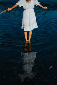 Low section of woman standing in sea