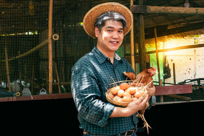 Portrait of smiling man holding ice cream in basket