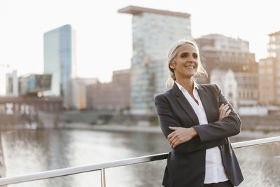 Confident businesswoman standing on bridge