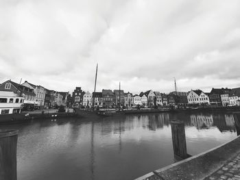 River by buildings against sky in city