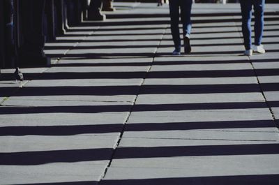 Low section of people walking on zebra crossing