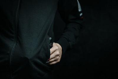 Midsection of man holding gun