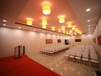 Empty chairs and tables in illuminated room