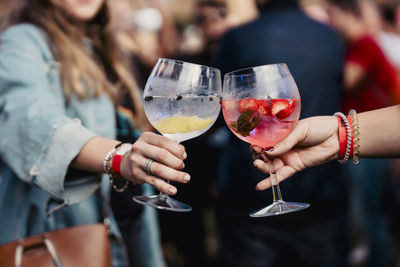 Midsection of woman holding wineglass