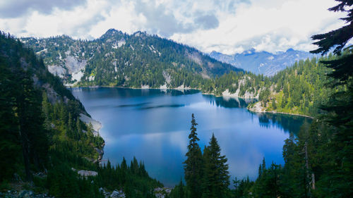 Scenic view of lake and mountains against cloudy sky