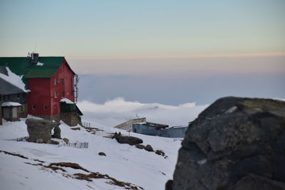 Houses on snowcapped mountain against sky