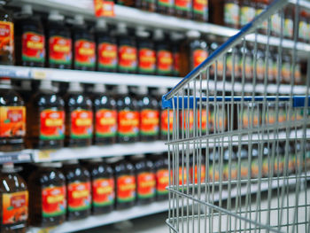 Conceptual image of shopping cart over blurry shelve of goods