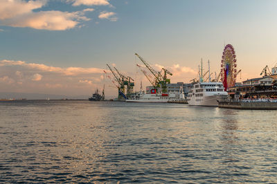 Commercial dock by sea against sky during sunset