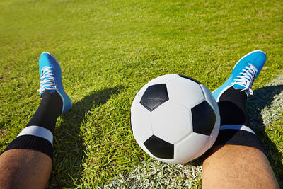 Low section of man playing soccer on field