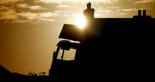 Low angle view of silhouette building against sky during sunset