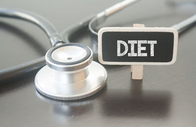 Close-up of diet text by stethoscope on table