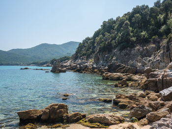 Scenic view of sea and mountains against sky