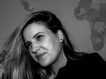Portrait of smiling young woman against gray background
