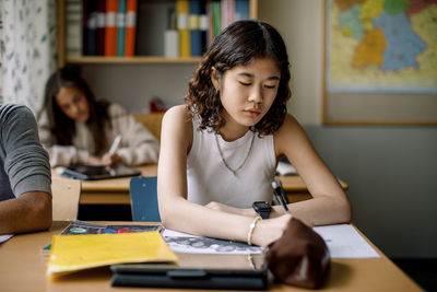 Teenage girl studying in junior high classroom