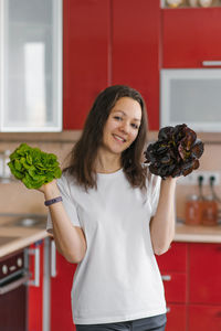 Young happy vegetarian nutritionist woman holds two types of salad in her hands