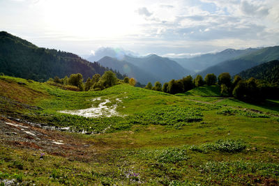 Scenic view of mountain range against cloudy sky