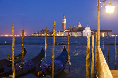 Gondolas moored on grand canal against church of san giorgio maggiore at dusk