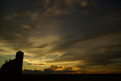 Low angle view of silhouette building against sky during sunset