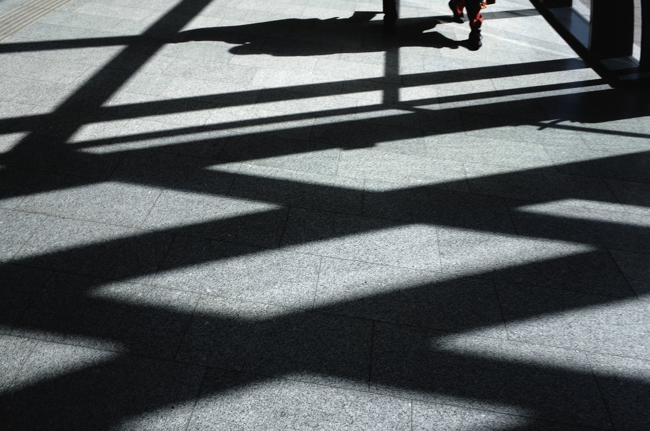 LOW SECTION OF MAN WITH SHADOW ON FLOOR