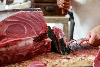 Close-up of man cutting tuna