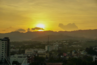 Silhouette buildings against sky during sunset