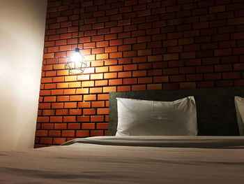 Close-up of illuminated lamp against wall at home