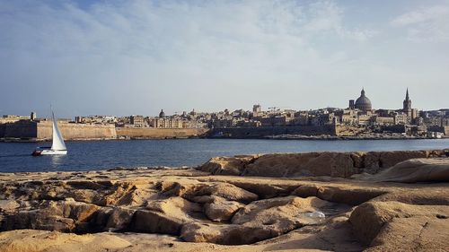 Scenic view of sea by city against sky