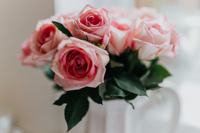 Upper view of white jug of pink roses.  light and airy edit.
